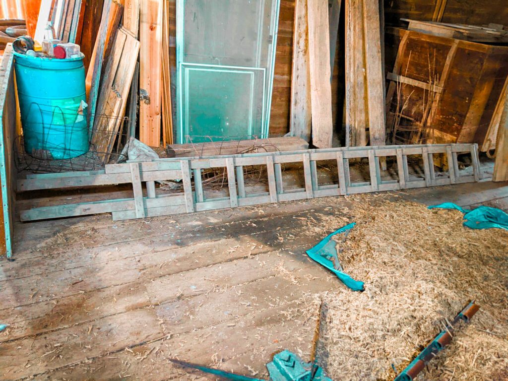 stacks of wooden ladders sitting in an old barn