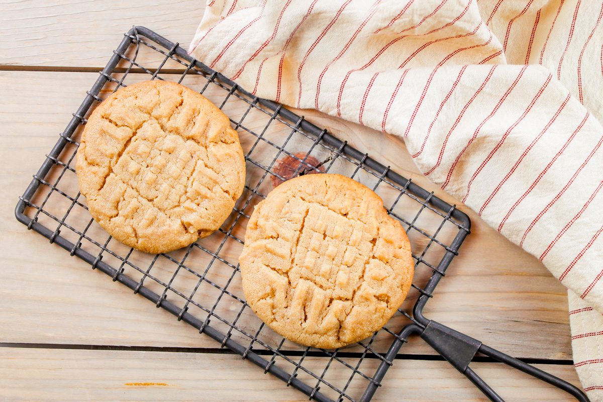 on a cooling rack sits two fresh baked peanut butter cookies