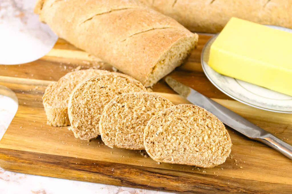 flour slices of bread beside a butter knife and a pad of butter