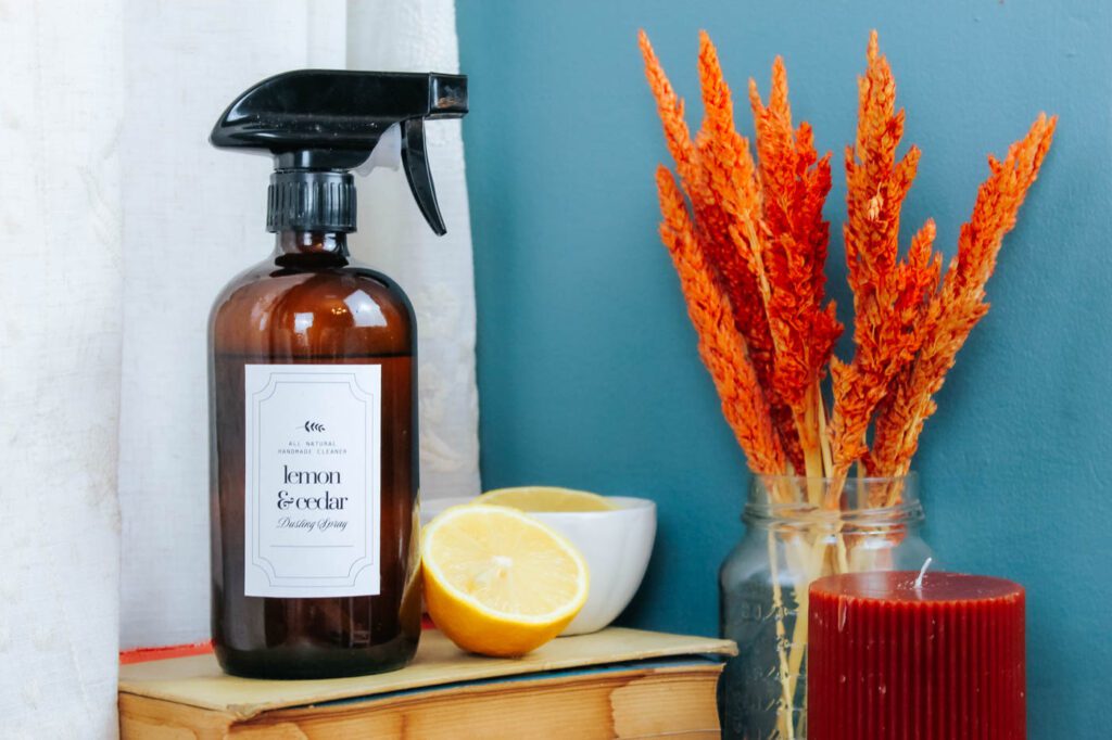 bottle of cleaning spray sitting on a pile of old books next to a lemon slice