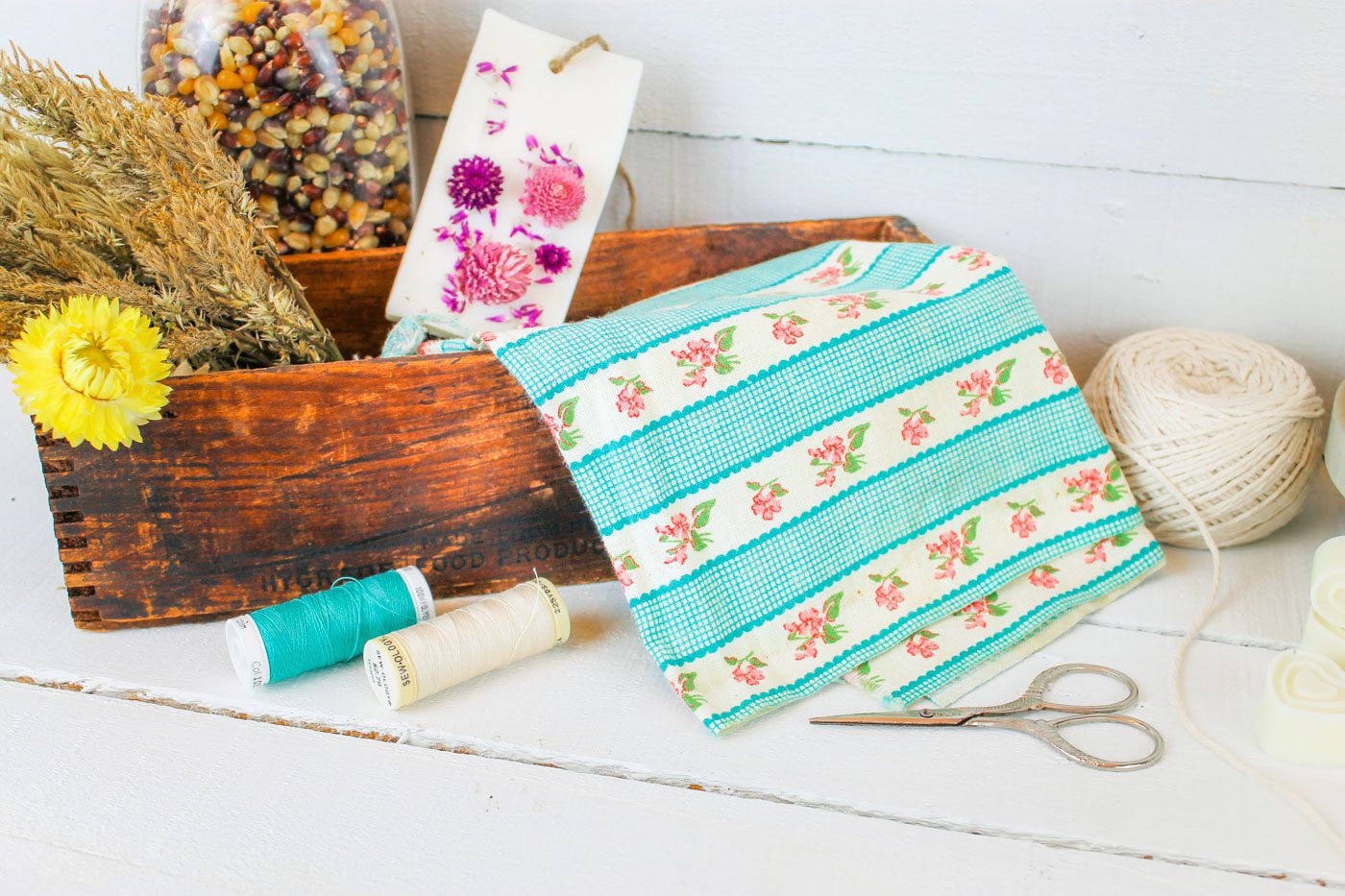 handmade gift making supplies featuring thread, dried florals, fabric and scissors