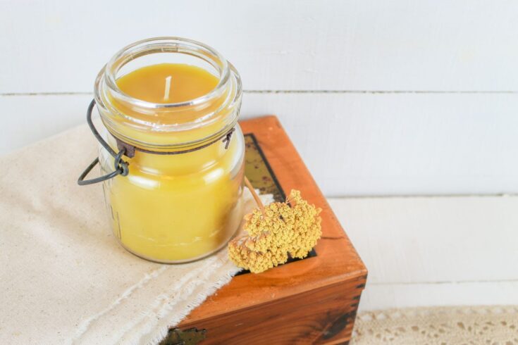 diy beeswax candle displayed on top of a vintage wooden box