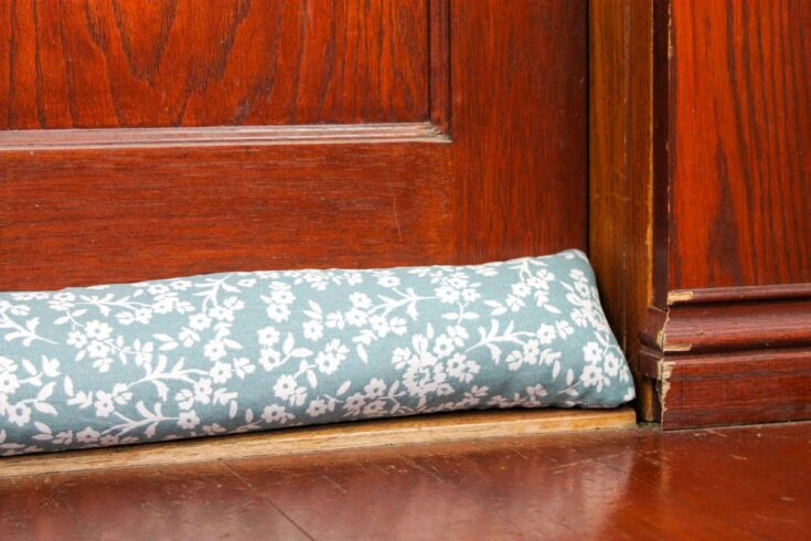 floral patterned door stopper sits in front of a wooden door