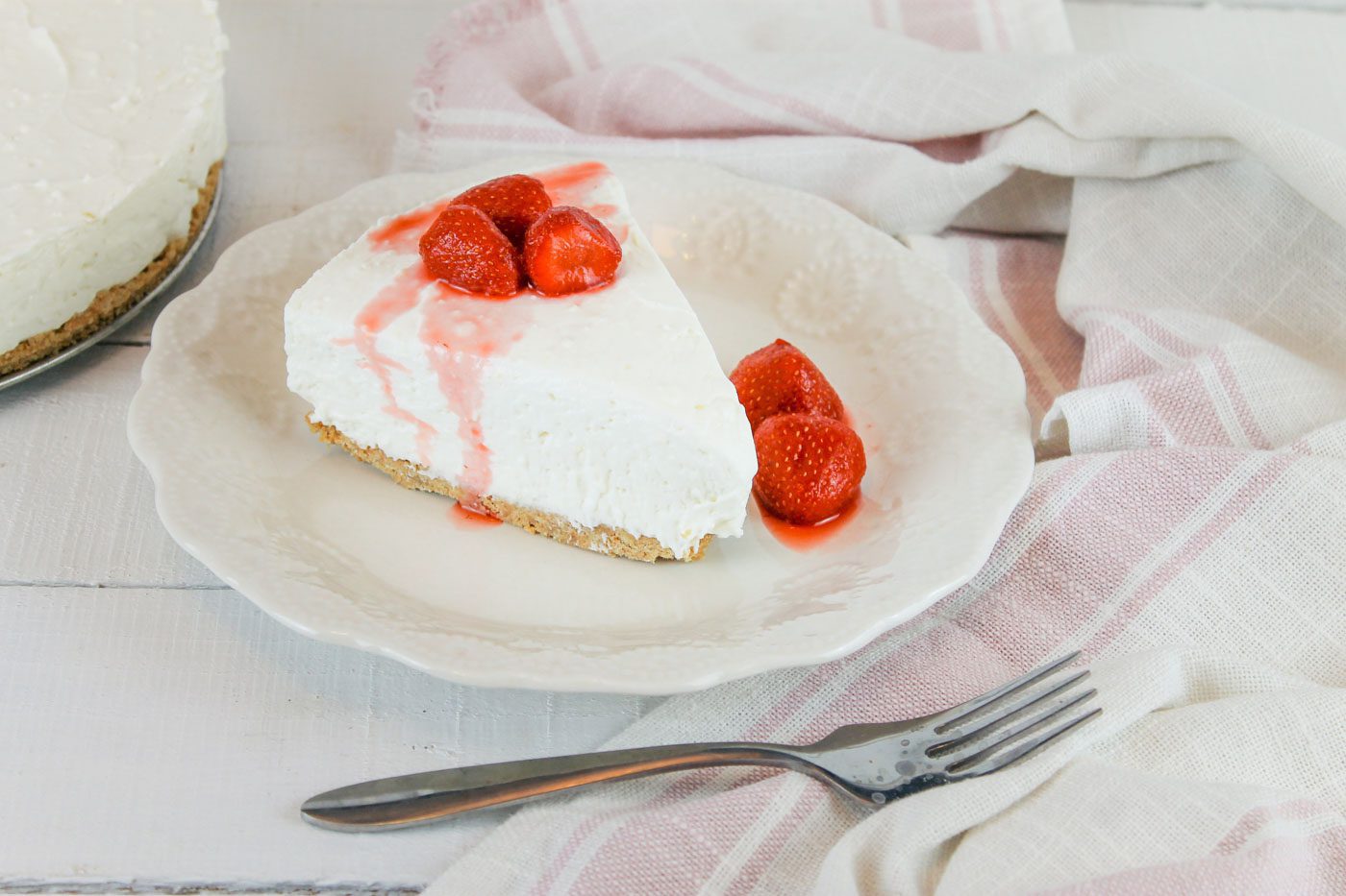 on a pink striped towel sits a plate of kefir cheesecake