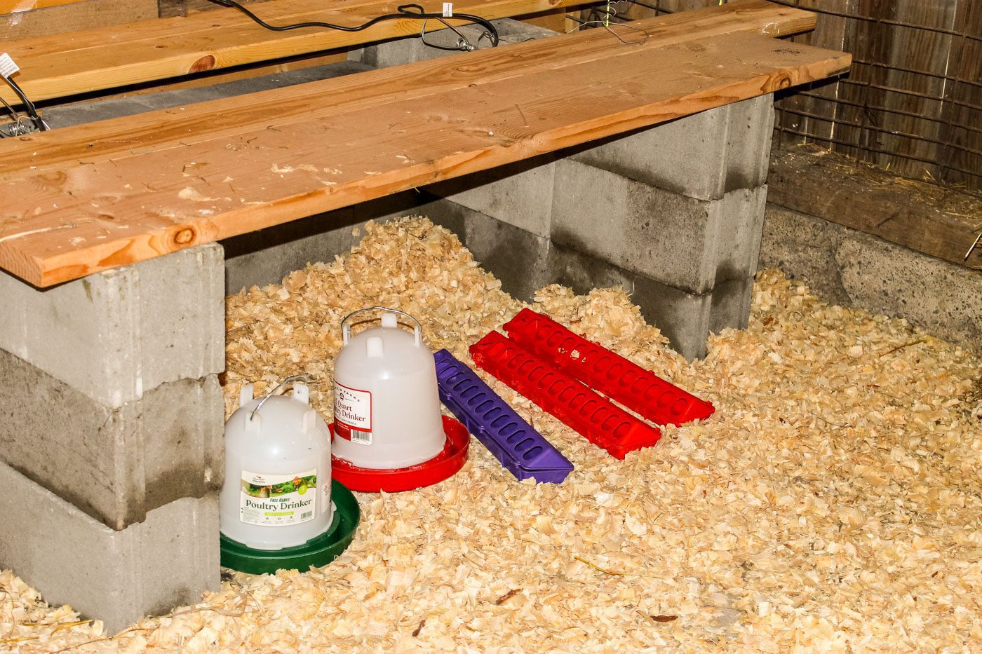 two rows of cinder blocks topped with some wooden boards to create a diy chicken brooder