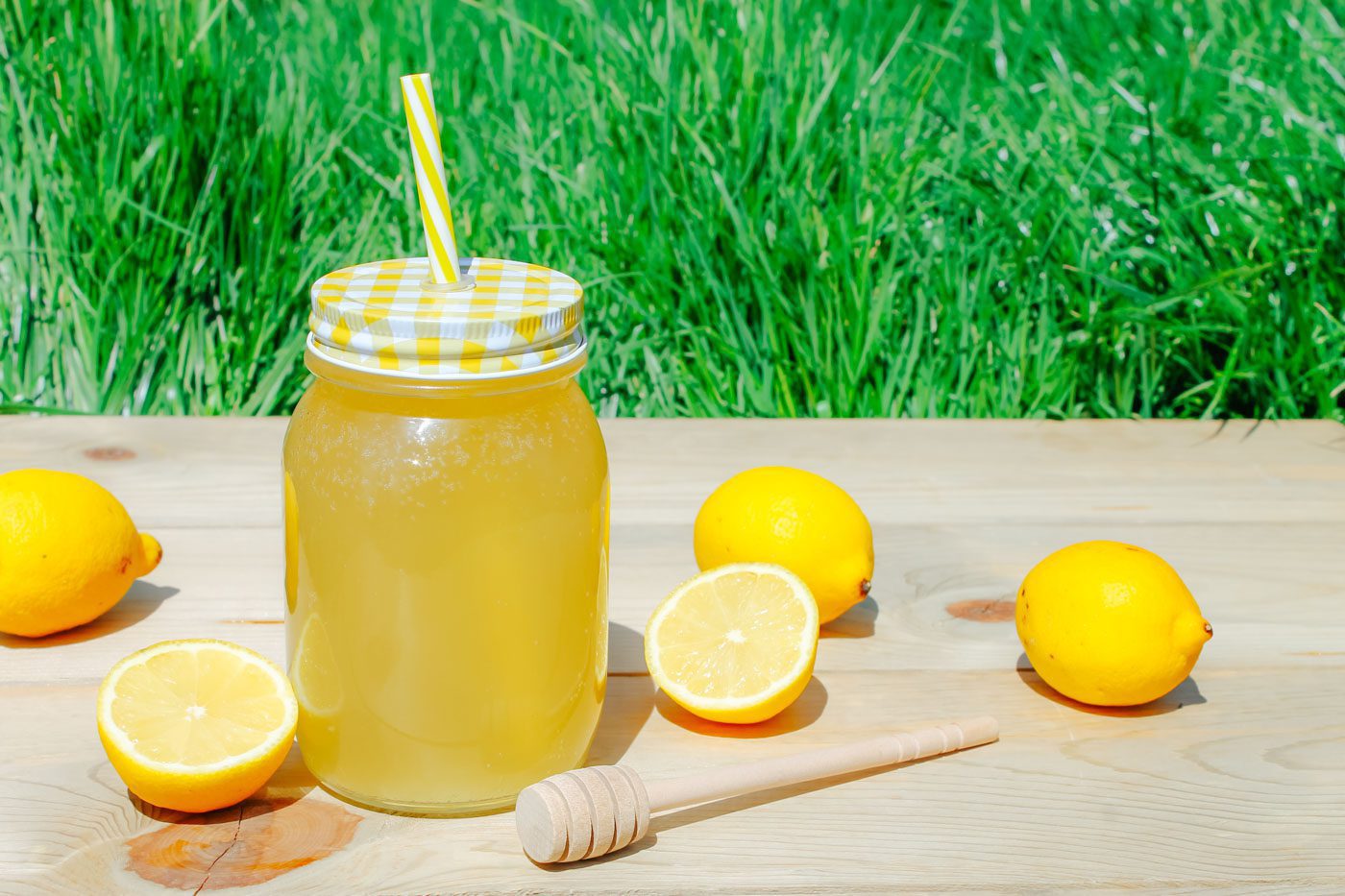 on a picnic table sits a mason jar full of lemonade