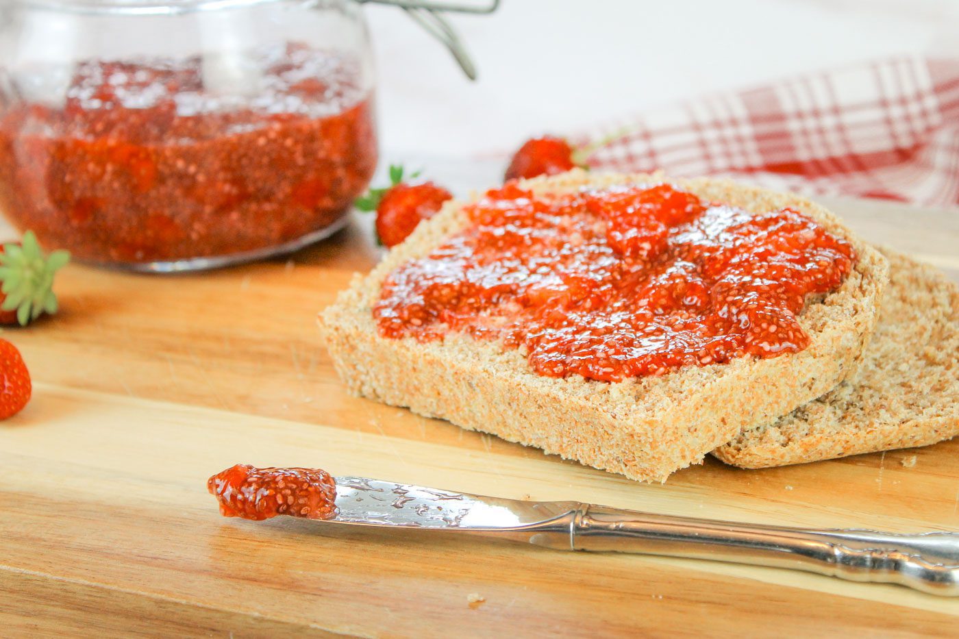 two slices of bread spread with strawberry jam