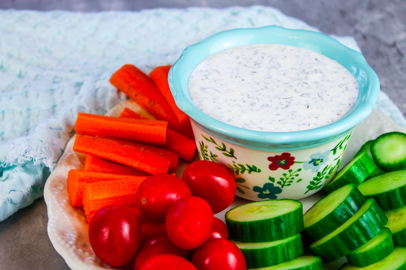 floral bowl with veggie dip surrounded by fresh veggies