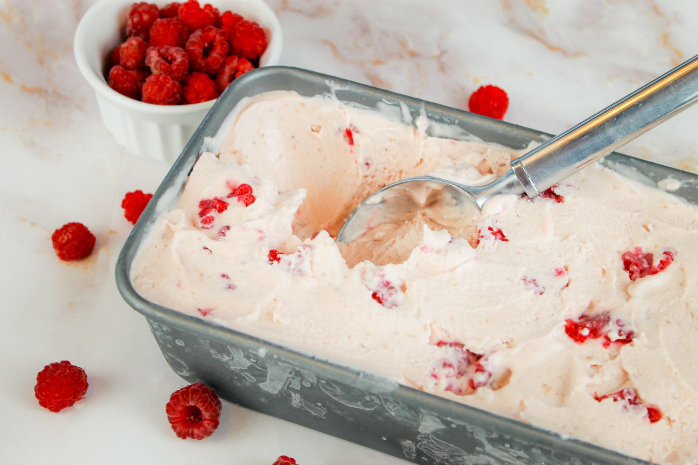 bread pan filled with frozen raspberry ice cream