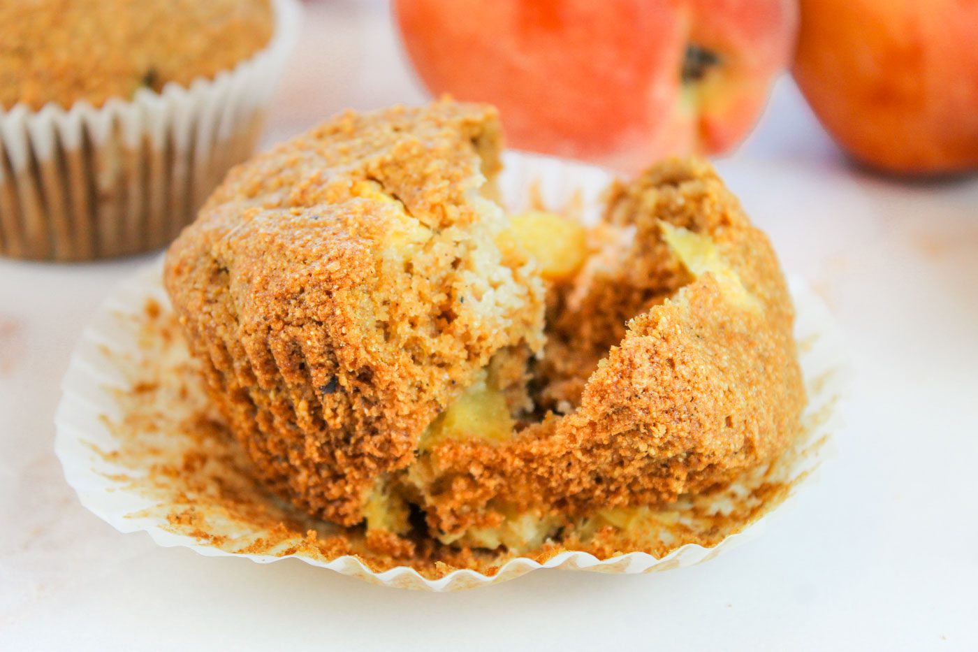 muffin cut in half revealing chunks of peaches and spices inside