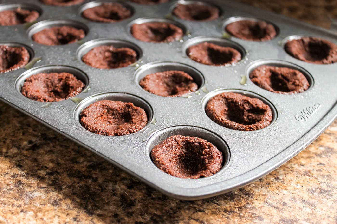 muffin pan filled with hot cocoa cookie dough