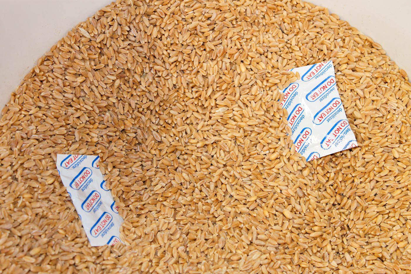 bucket of grains with two oxygen absorbers sitting inside