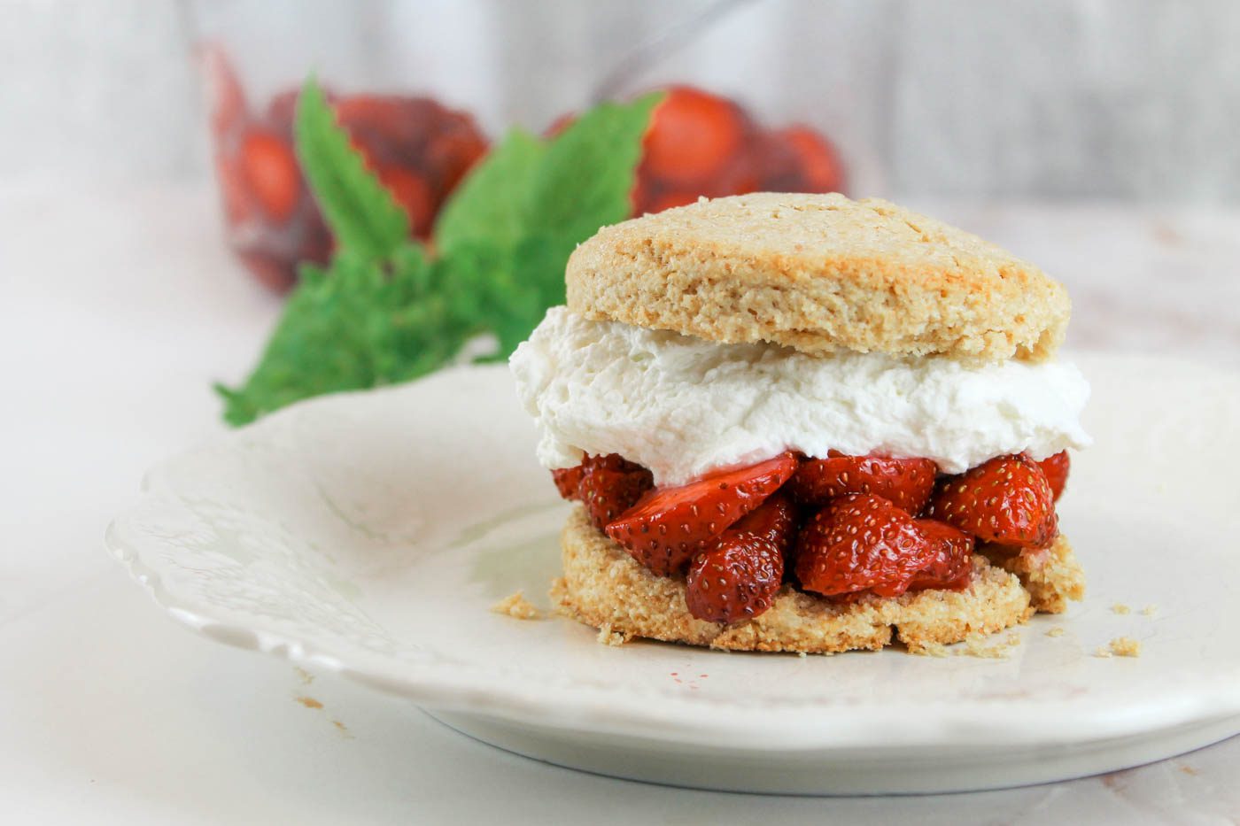 biscuit filled with strawberries and cream sitting on a plate on the countertop