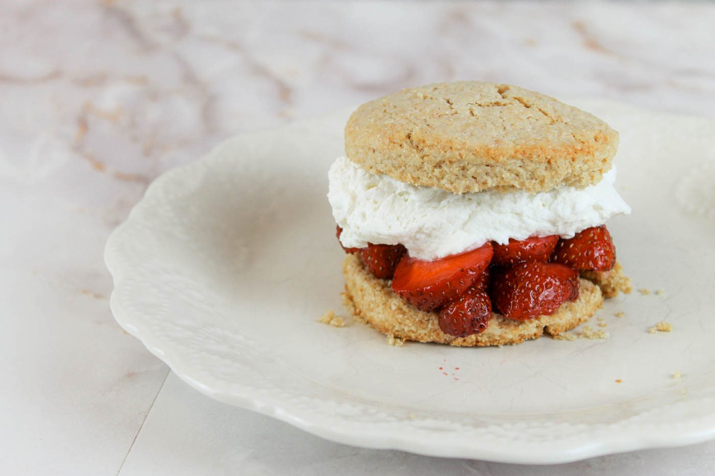 shortcake dessert filled with strawberries on a glass plate