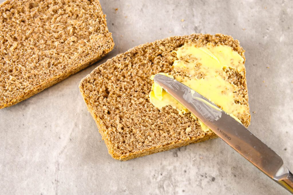 knife buttering a slice of homemade bread