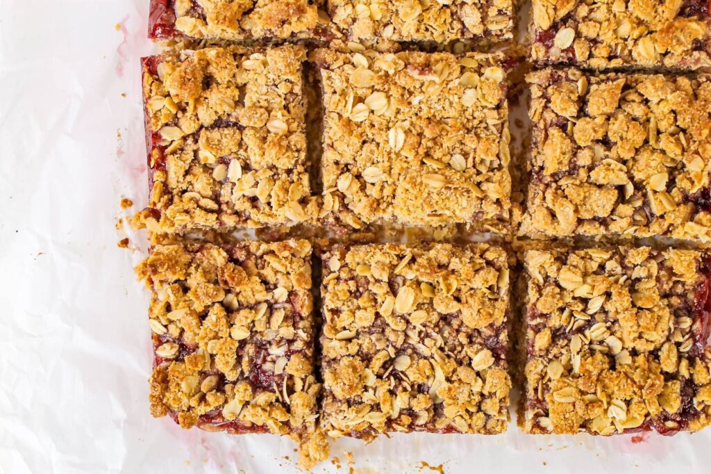 9 oatmeal jam bars laying on a piece of parchment paper