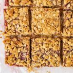 9 oatmeal jam bars laying on a piece of parchment paper