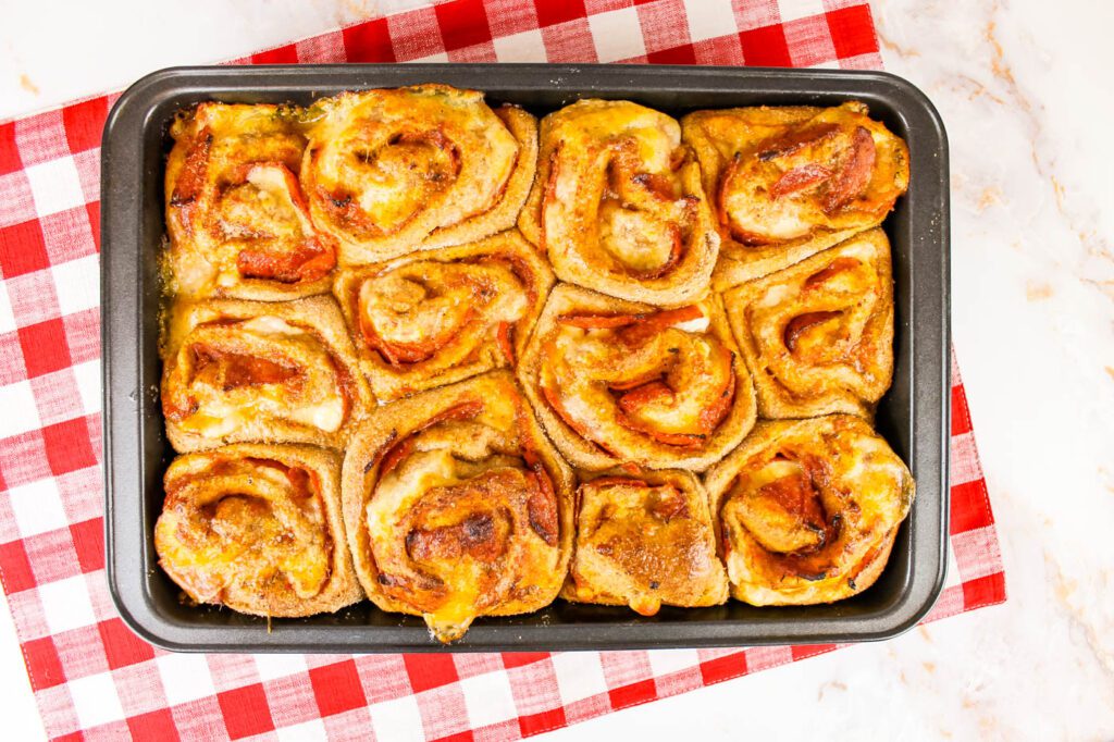 large baking pan filled with pizza rolls sitting on a kitchen towel