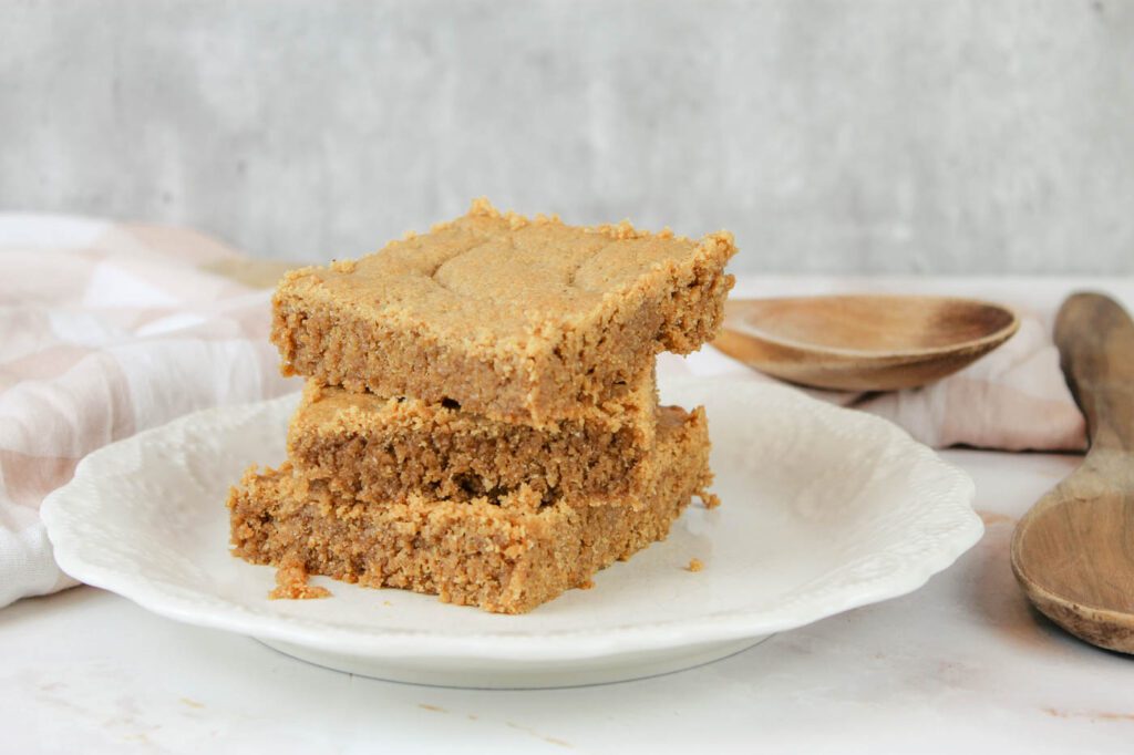 plate full of peanut butter cookie bars next to a set of wooden spoons