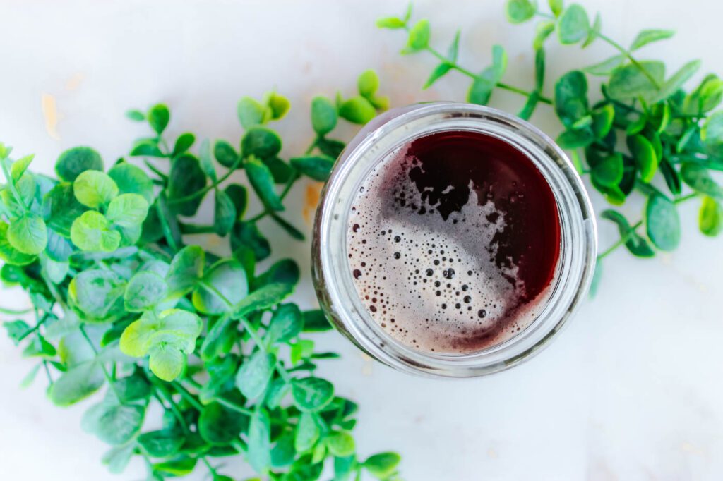 top view of a jar of soda sitting on a kitchen countertop surrounded by some green leaves