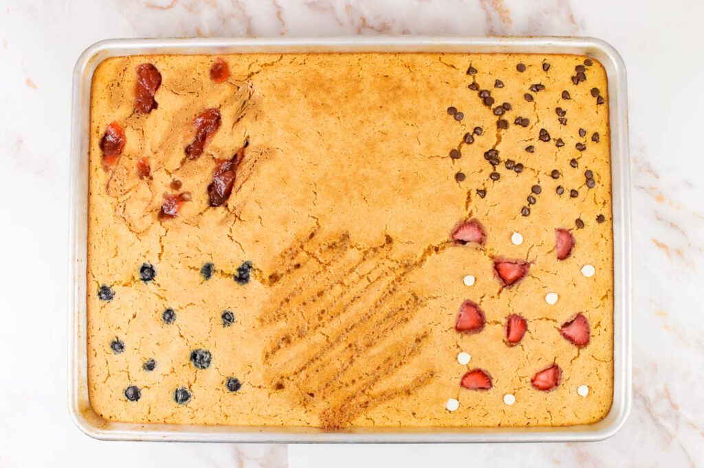 pan filled with pancake batter covered with fruit and chocolate