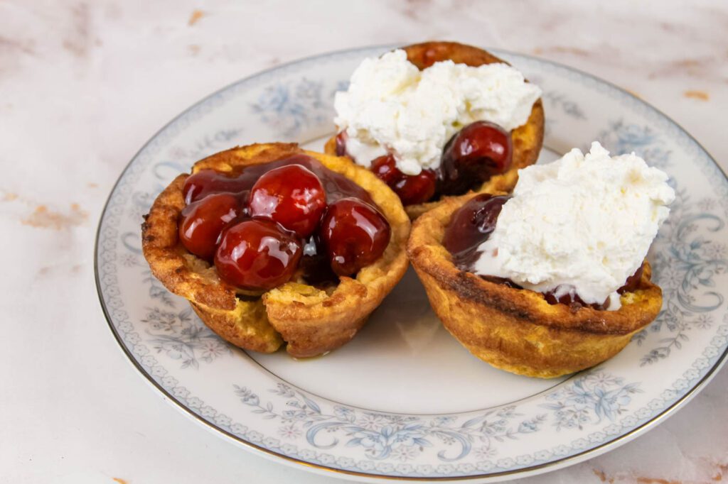 3 mini pancakes topped with fruit and whipped cream