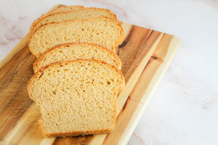 slices of bread laid upon each other on a wooden cutting board