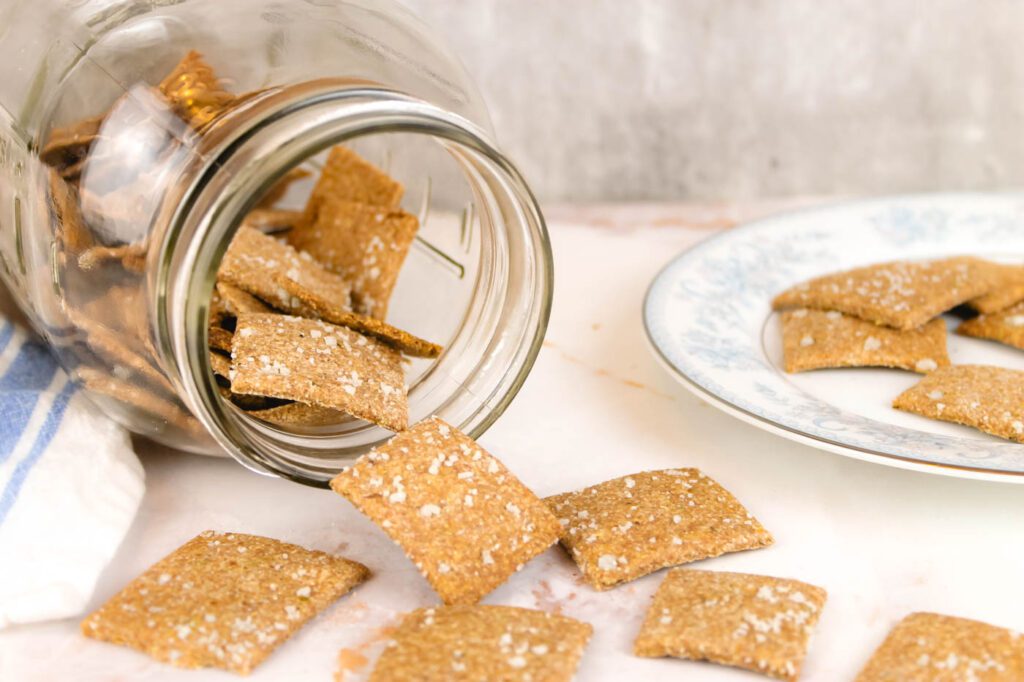 jar with crackers spilling onto marble surface