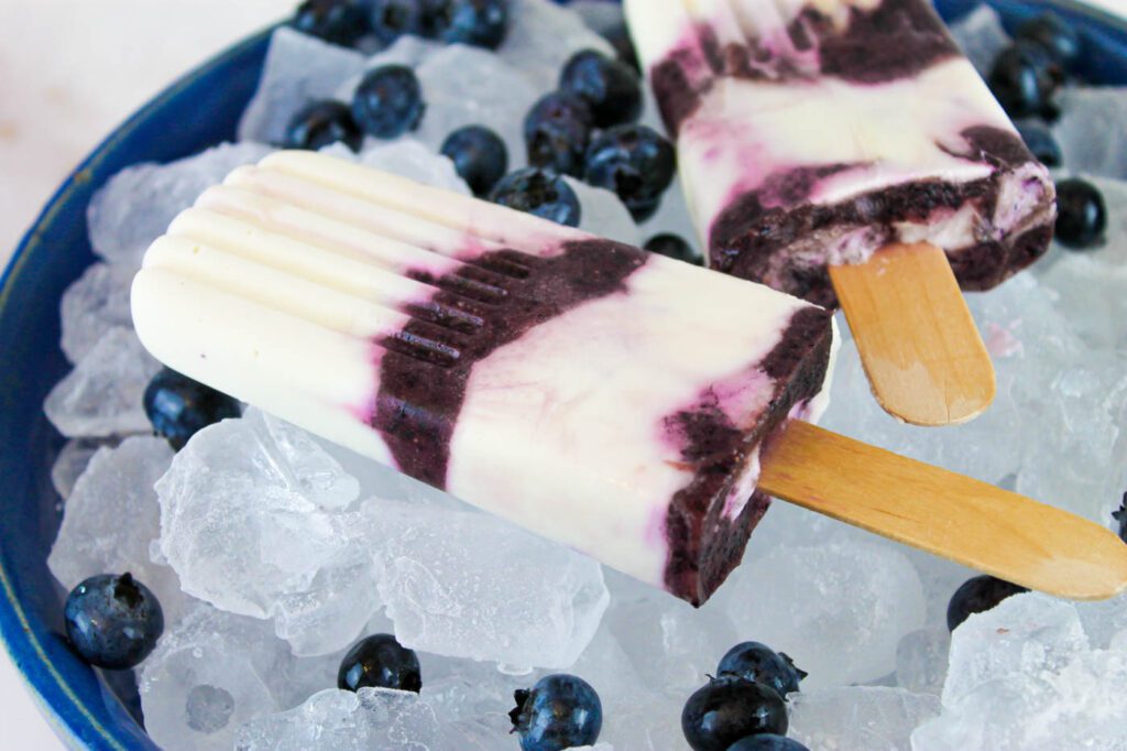 two frozen pops sits in a bowl of ice cubes