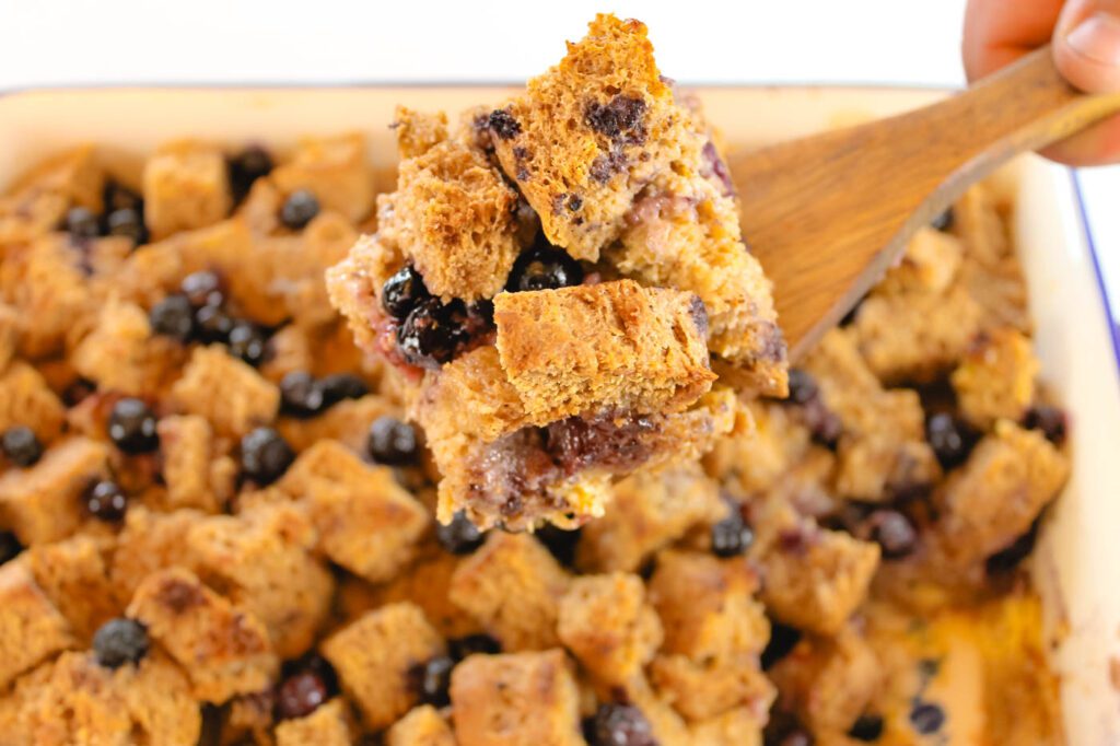 man scoops up a slice of french toast casserole