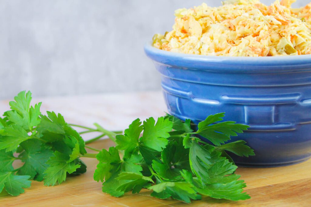 fresh green herbs and a glass bowl filled with mustard coleslaw