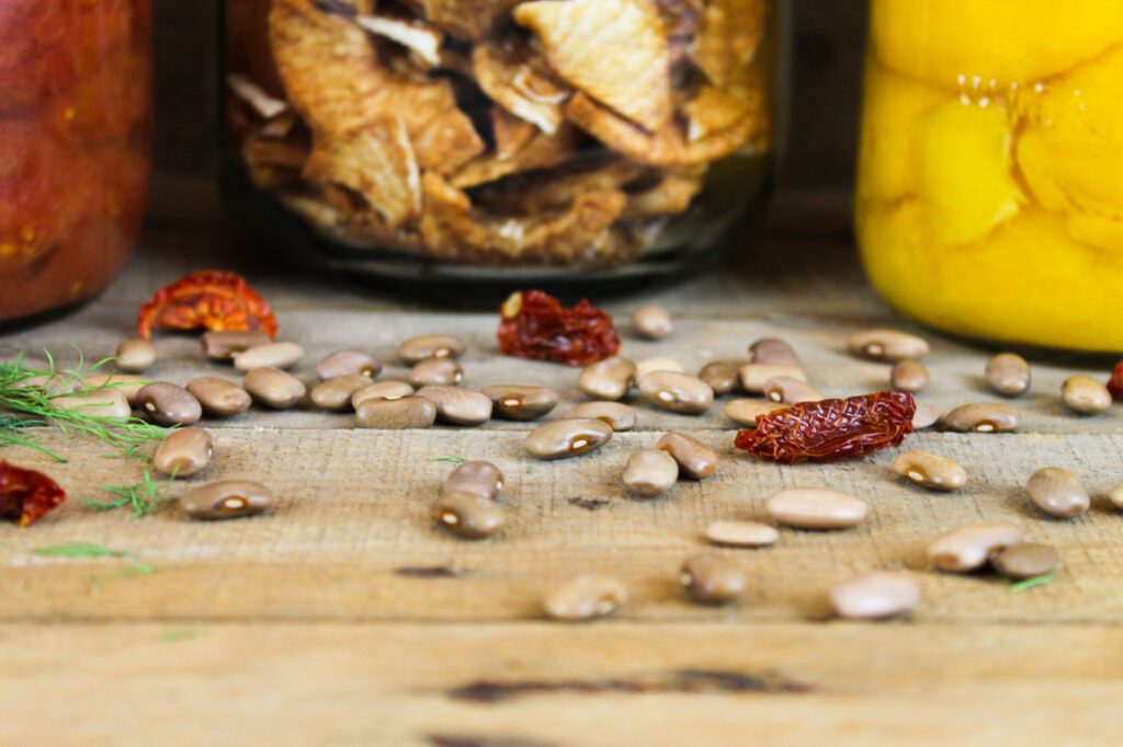 dried beans and dried tomatoes scattered across a wooden surface