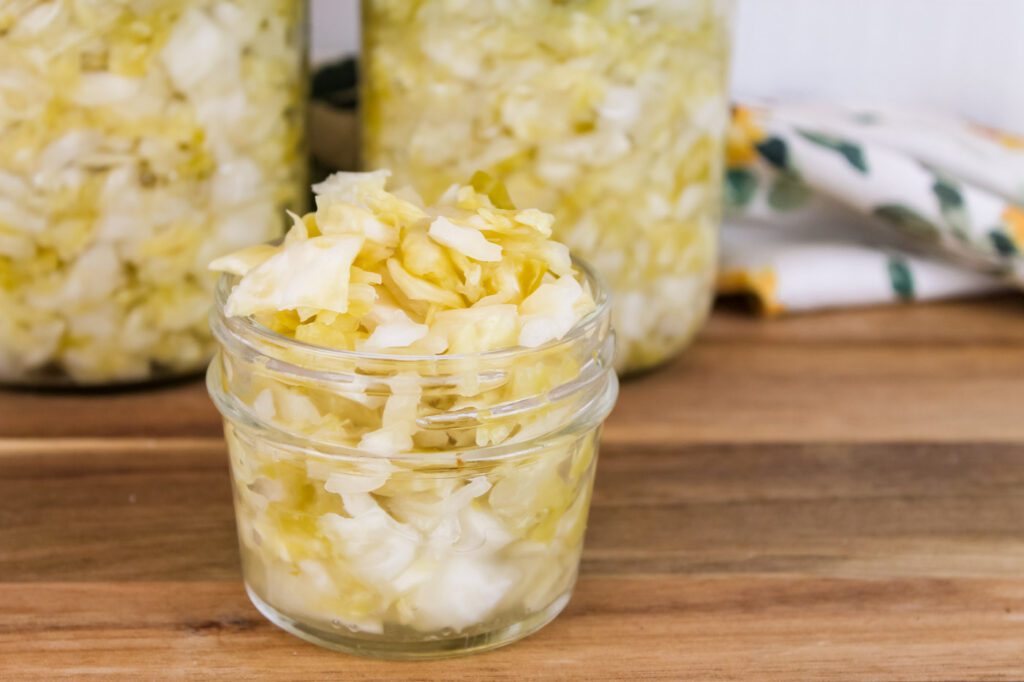 small jar of fermented sauerkraut sitting on a cutting board