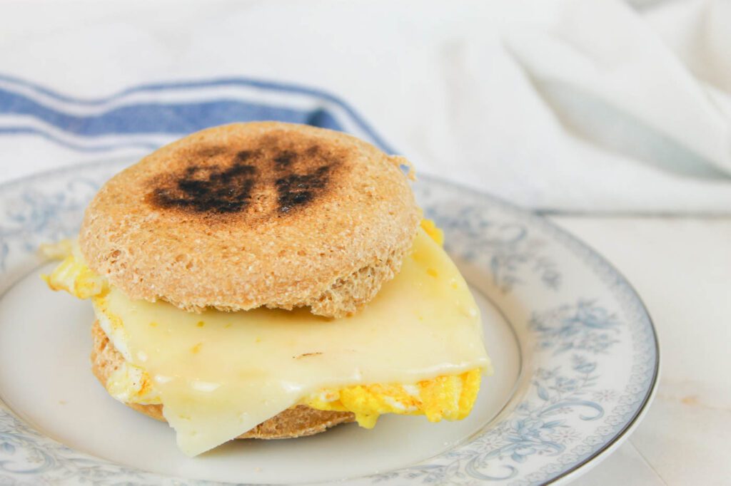 egg muffin sandwich with cheese melting out the side