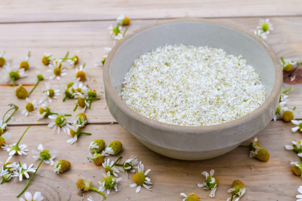 a bowl of salt sitting next to dried herbs to begin preserving them