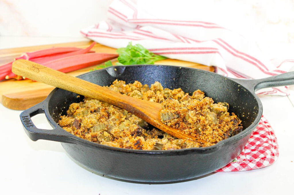black skillet filled with okra sits on a checkered hot pad