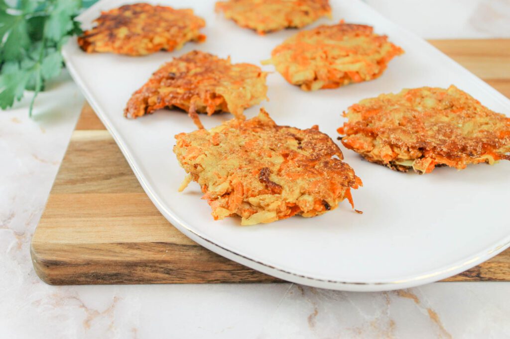 fried zucchini fritters sitting on top of a platter inside a kitchen