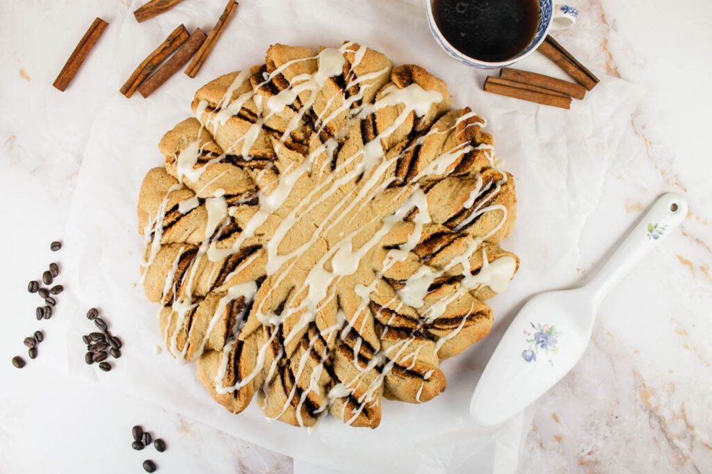 cinnamon twist bread covered in a glaze sits on a marble countertop