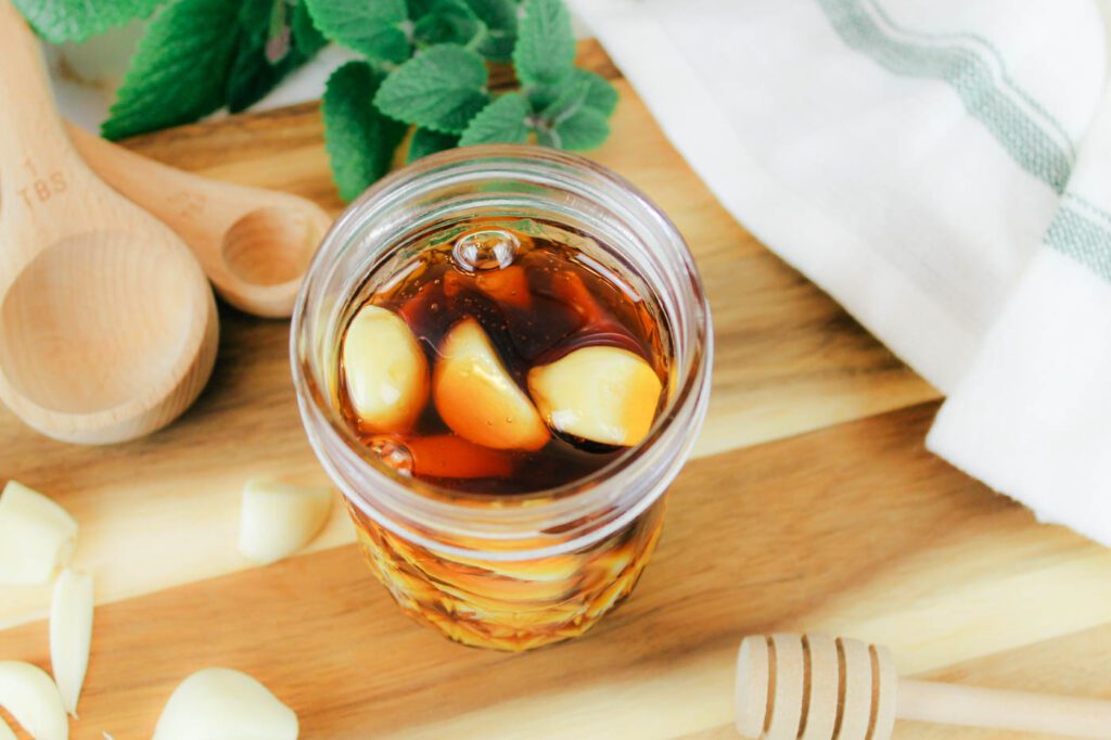 top view of jar filled with honey and garlic cloves