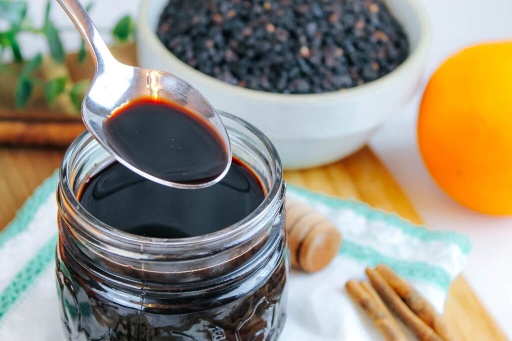 spoon filled with homemade elderberry syrup