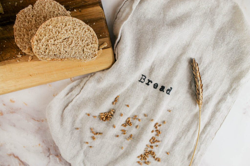 a bread bag sits next to a tray of sliced bread