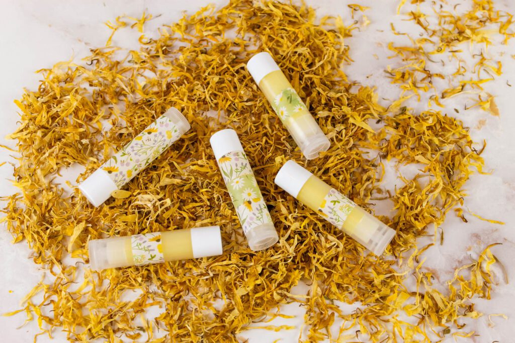tubes of chapstick laying on a pile of dried herbs