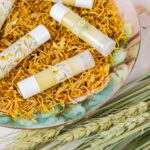 a plate filled with dried herbs and homemade calendula lip balm