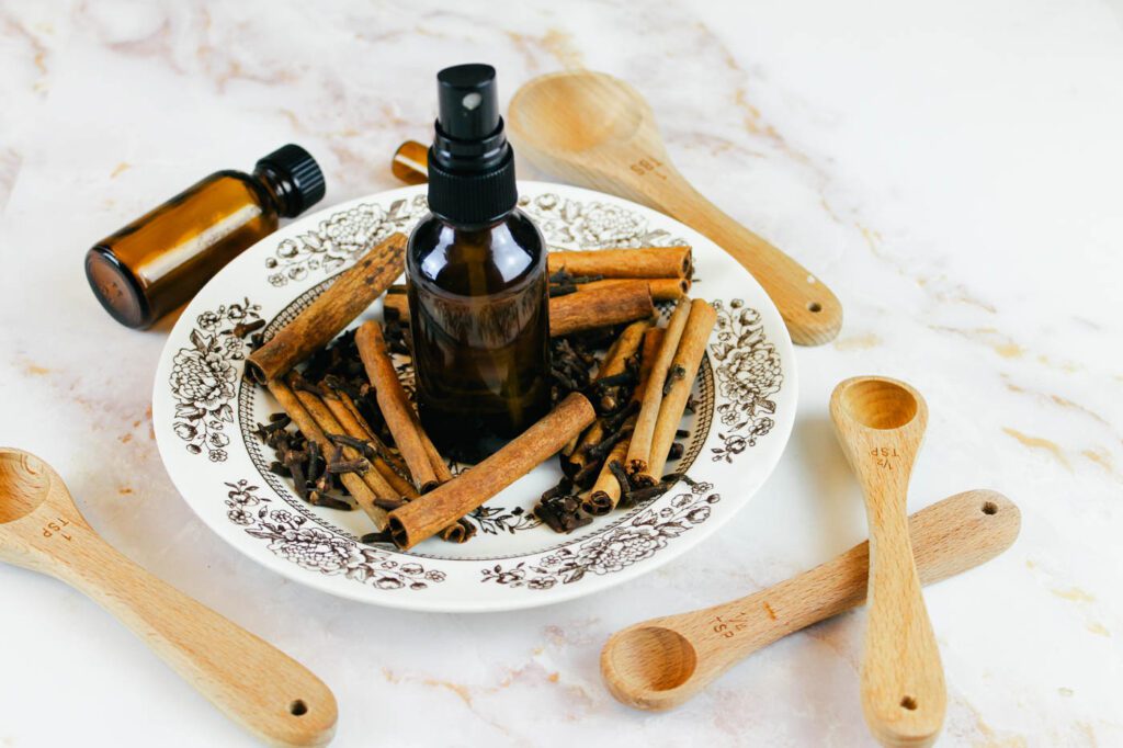 bottle of room deodorizer sits on a plate beside wooden measuring spoons