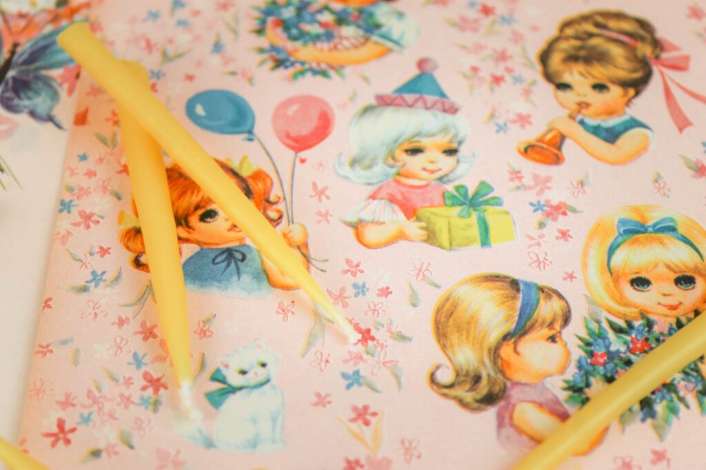 vintage wrapping paper with a few beeswax candles laying on top