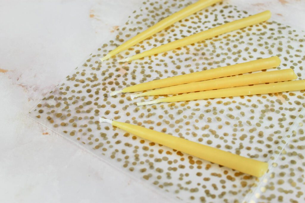 homemade candles sitting on a confetti covered plastic bag