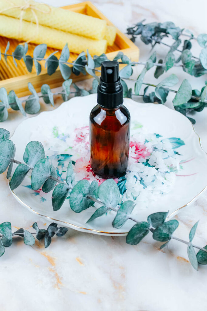 homemade magnesium spray on a floral plate next to dried botanicals