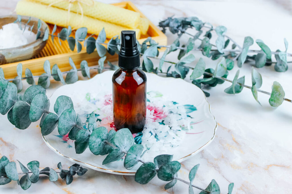 glass spray bottle filled with diy magnesium spray sitting on a floral plate