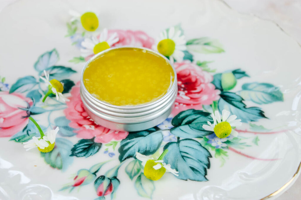 tin of herbal salve on a floral plate